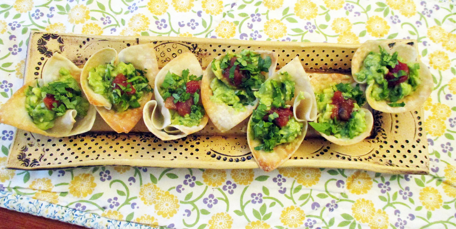 Wonton cups filled with guacamole, salsa and cilantro.